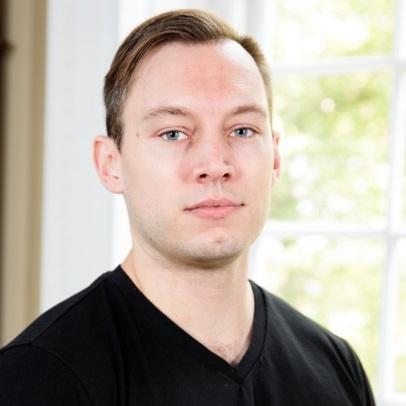 Headshot of Alex Pyron in front of a window